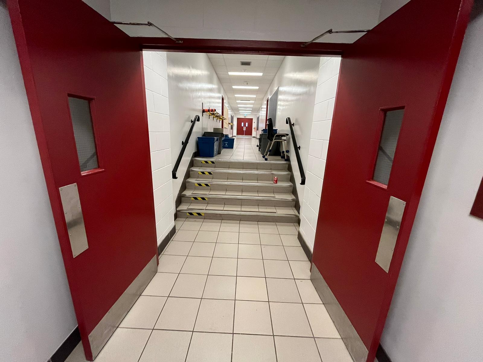 Trillium Lakelands DSB school, Kawartha Lakes, Ontario โ corridor with repainted walls and red doors by P&G Renovation