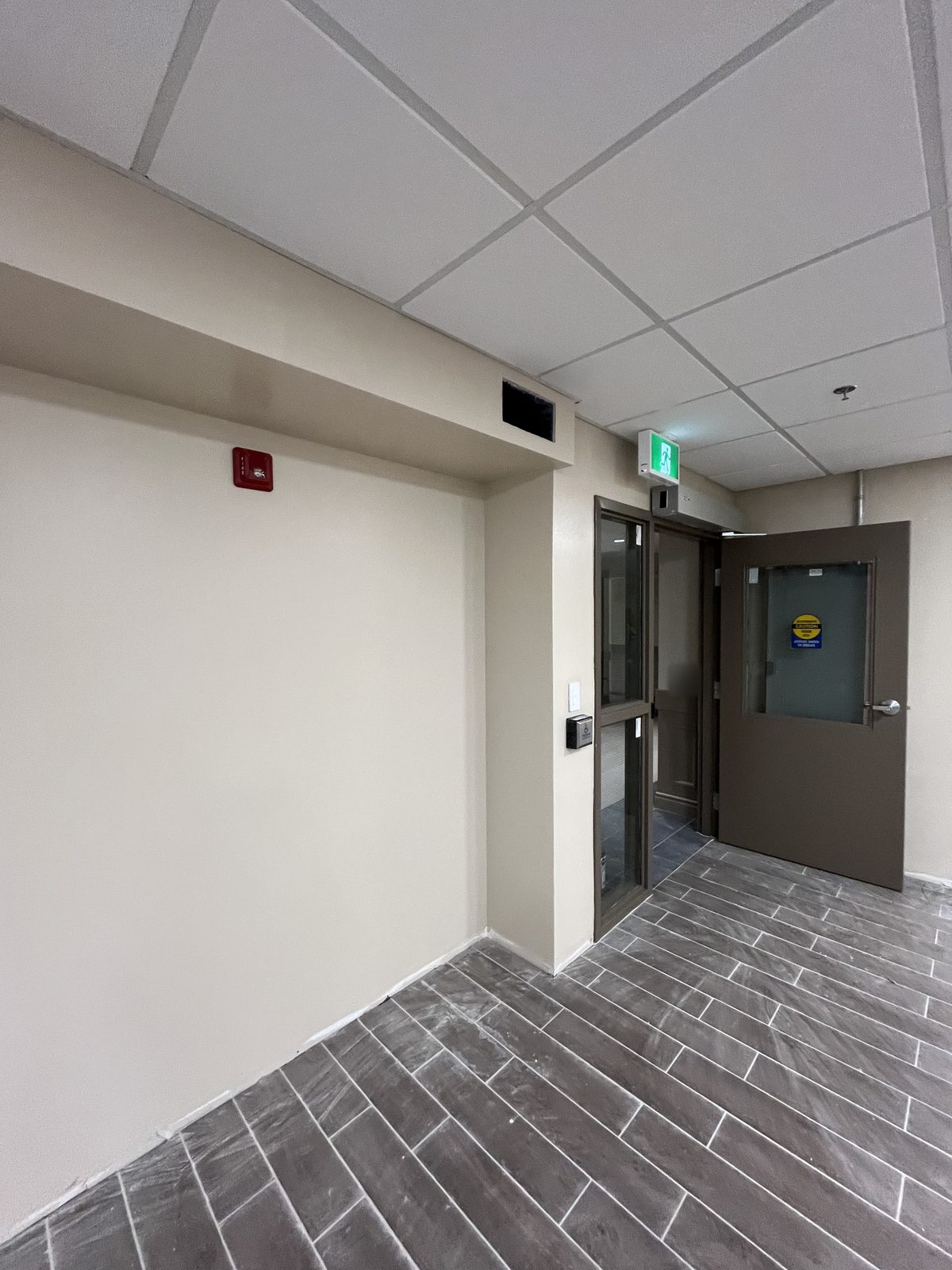 Entry vestibule with beige painted walls and bulkhead and a brown painted door and frames at 40 Polonia in Brampton