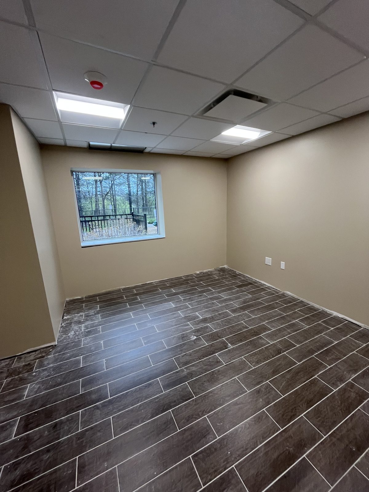 Room with beige painted walls, a large window and grey plank tile floor at 40 Polonia in Brampton