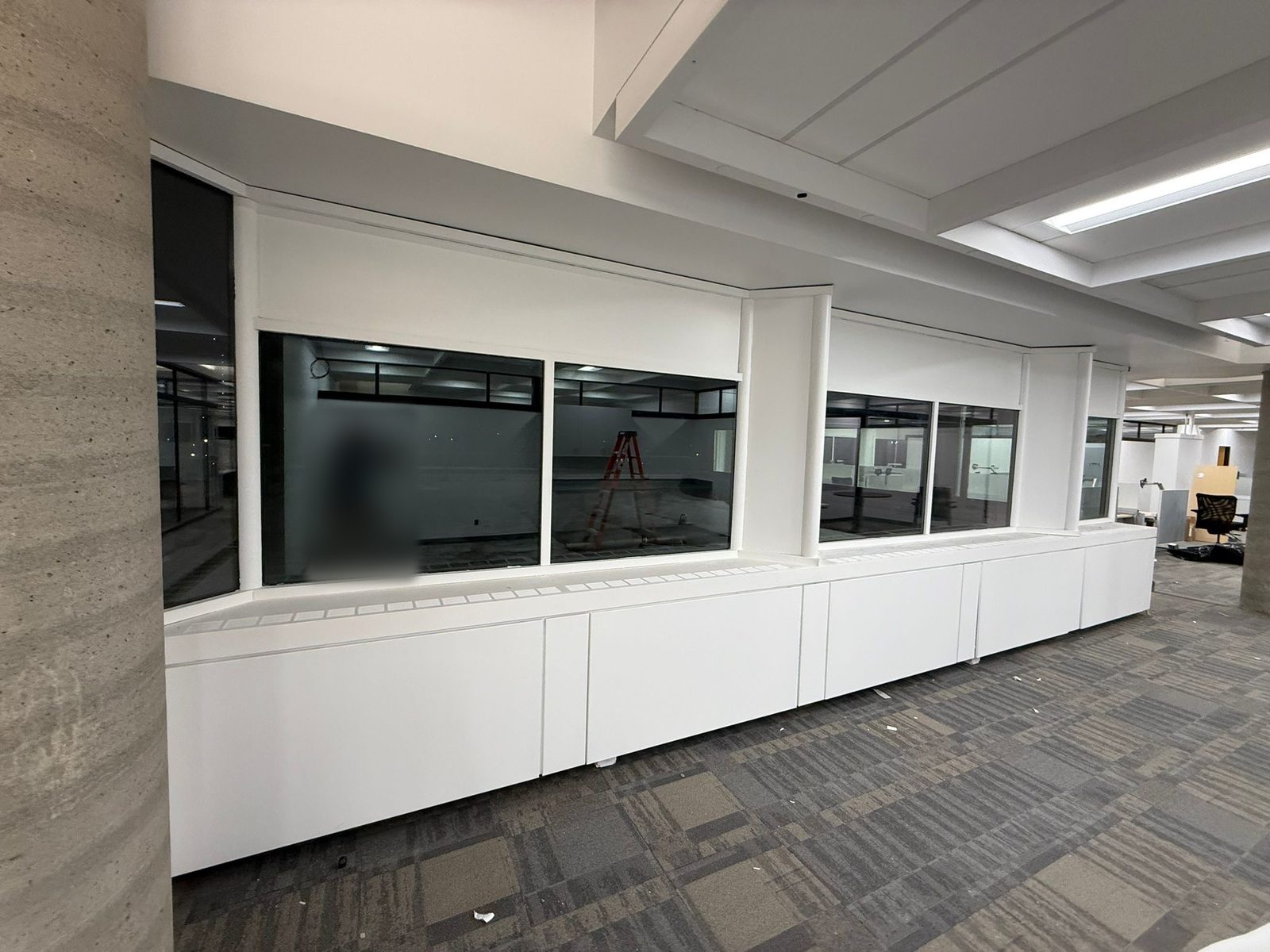 Long run of white painted window bulkheads and millwork cabinets beside interior glazing on the 6th floor at 4900 Yonge Street, Toronto
