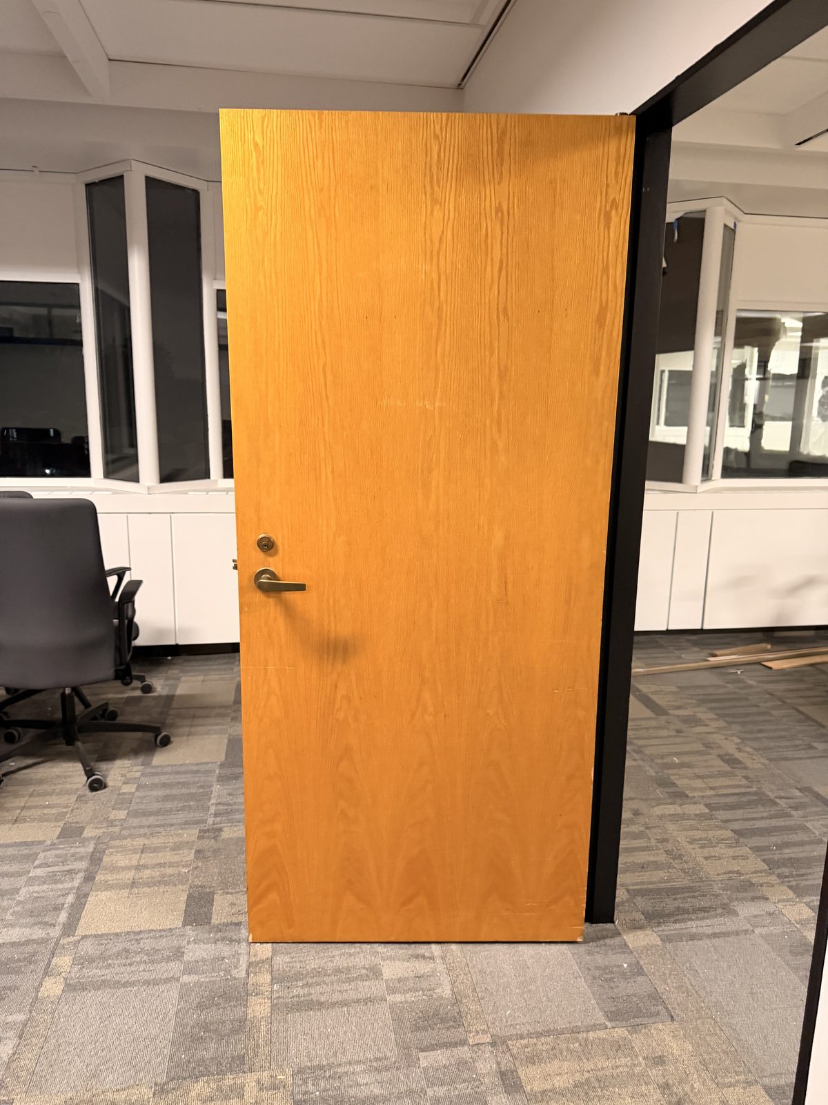 Wood-veneer office door in a black frame between white walls on the 6th floor at 4900 Yonge Street, Toronto