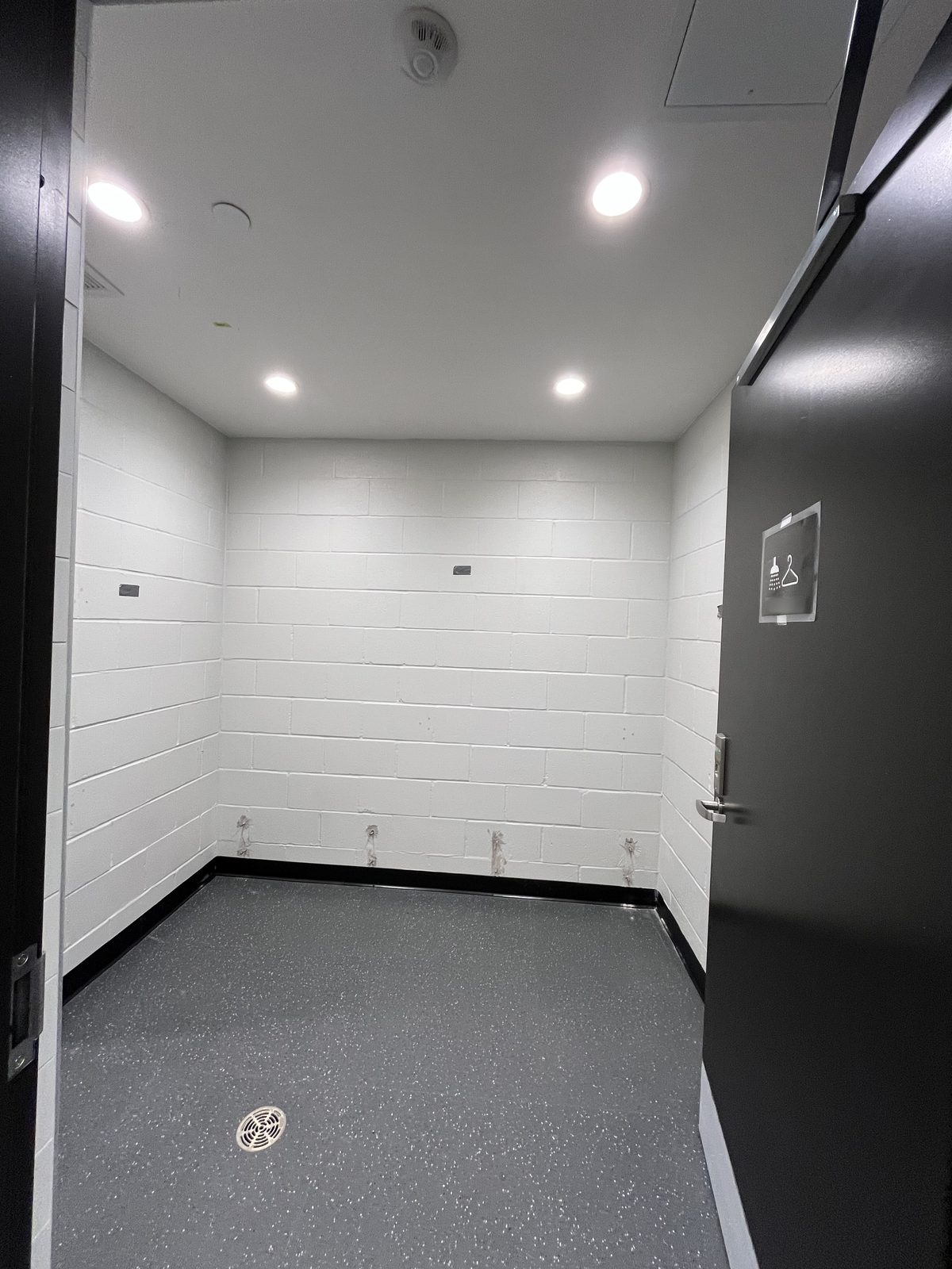 Change room with white painted block walls, black base and a black door at the Albert McCormick Community Centre in Waterloo