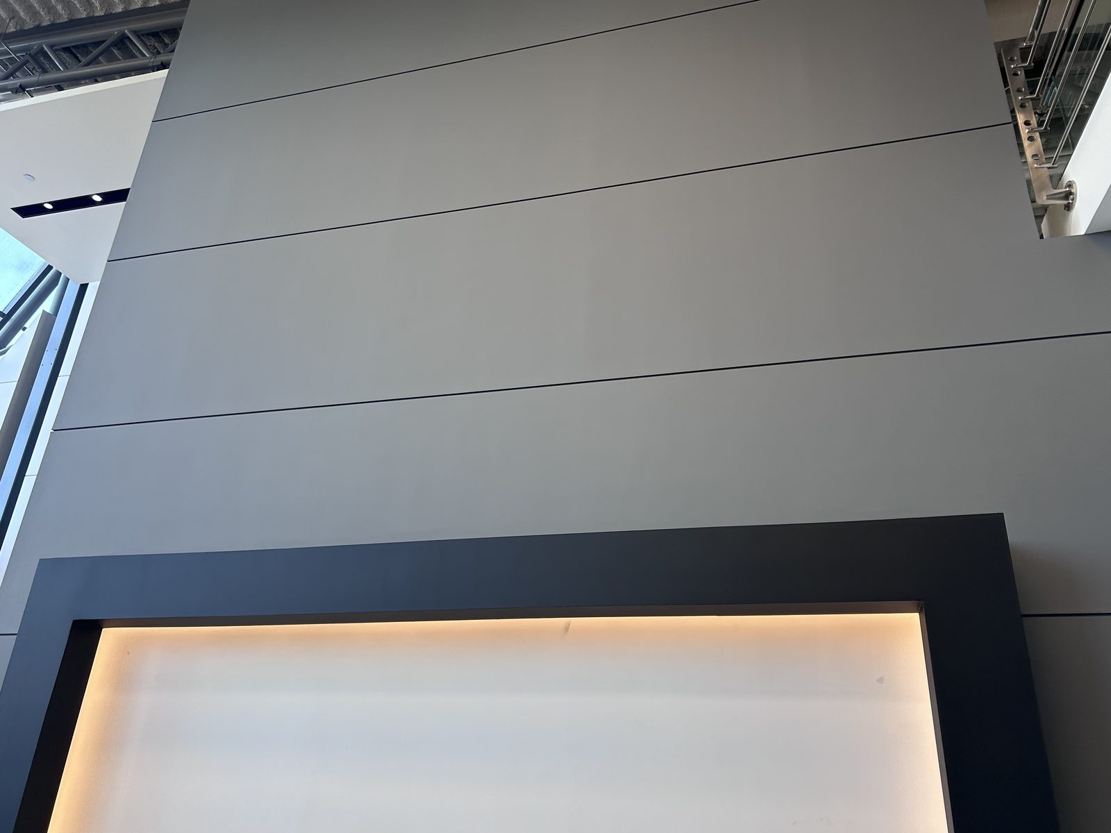 Grey painted panel wall above a dark frame with a backlit opening