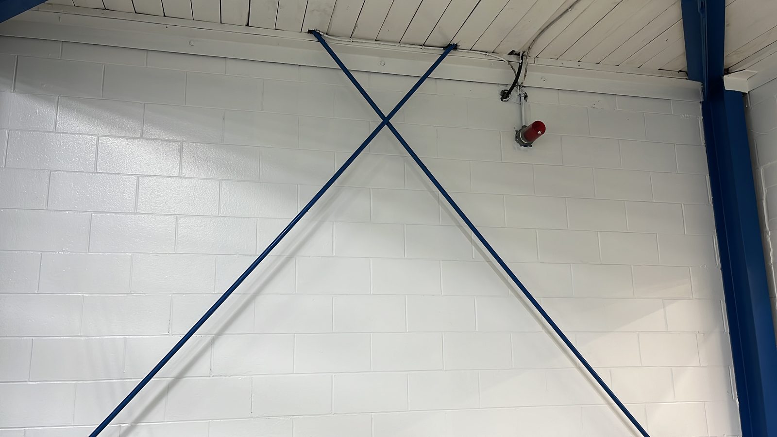 White painted block wall with blue steel cross-bracing, Elora Community Centre
