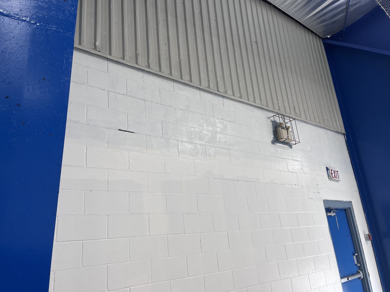 White painted block wall with blue steel column and blue door, Elora Community Centre
