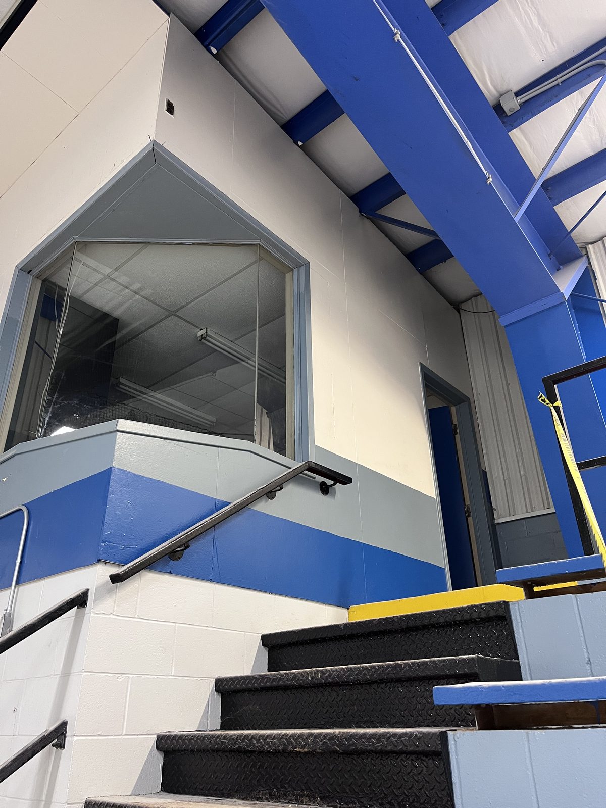 Stairway to the upper booth with blue and grey painted trim, Elora Community Centre