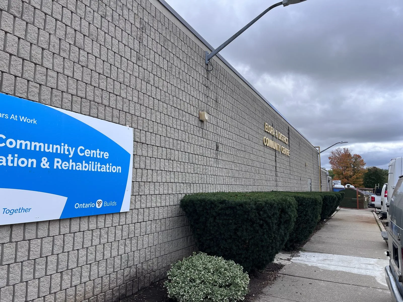 Exterior block wall with renovation and rehabilitation sign, Elora Community Centre