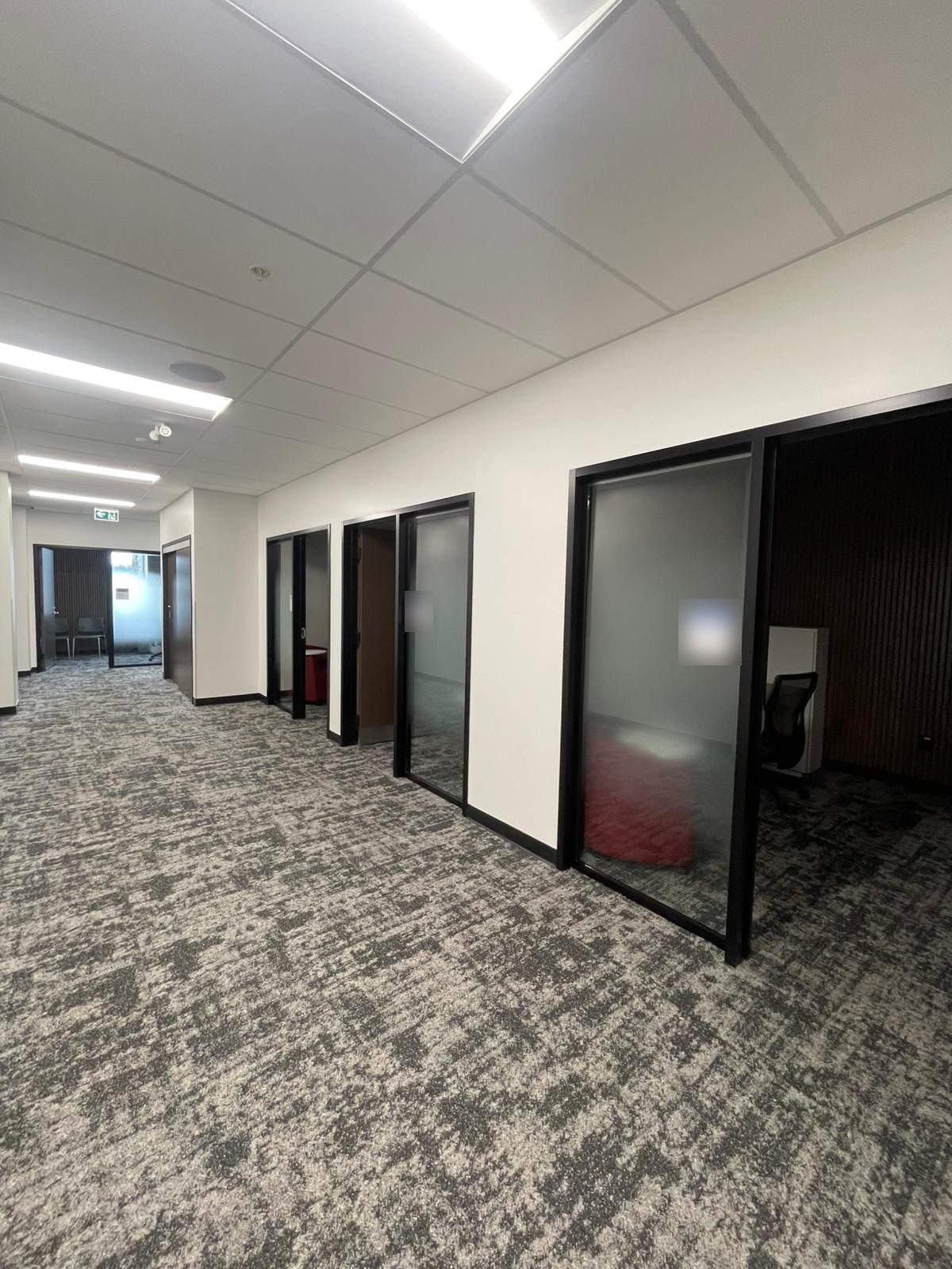 Office suite corridor with white painted walls and black-framed glass offices in Building B at Georgian College in Barrie