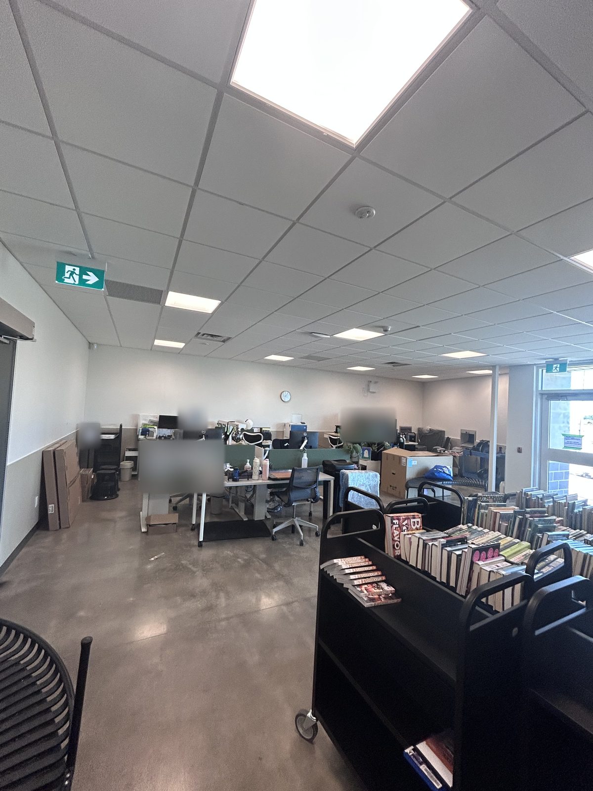 Workroom with desks, boxes and book carts during move-in