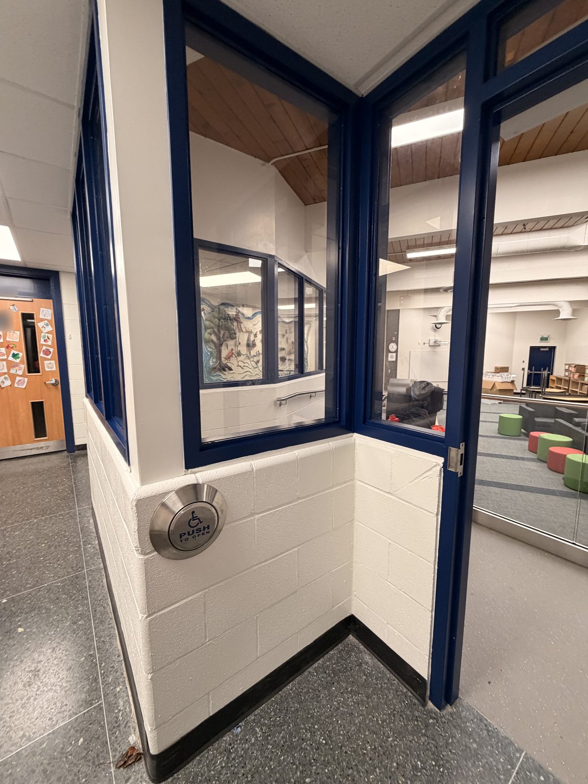 Corner of a room enclosure with dark blue painted window frames above a white painted block base at Roseneath Centennial School in Roseneath